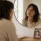 Mujer frente al espejo reflexionando sobre la invalidación emocional en la infancia